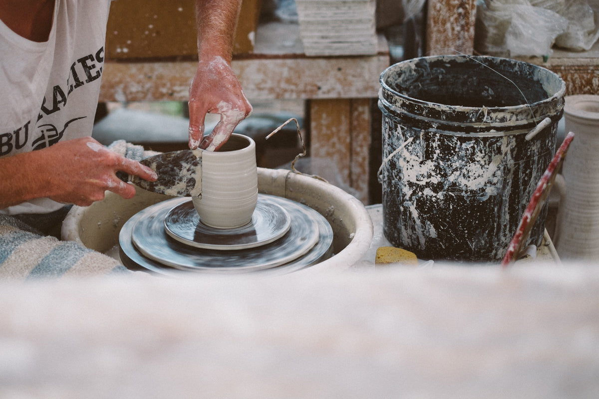 Someone throwing clay into vessels